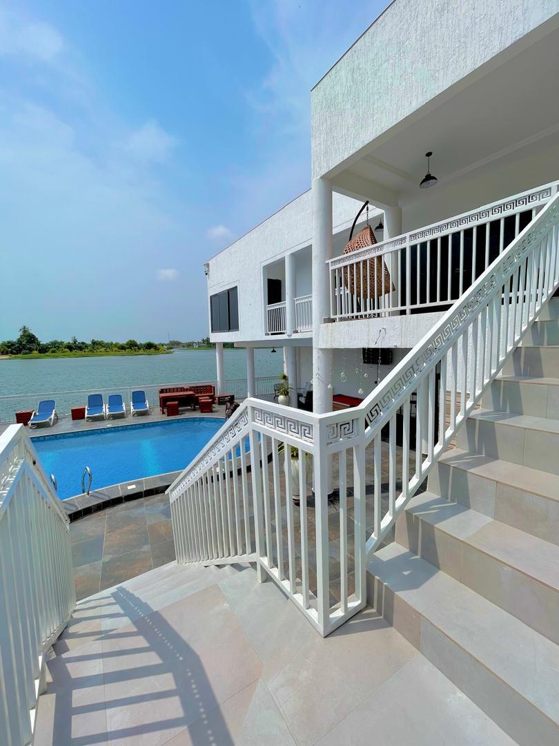 White villa with poolside stairs overlooking the estuary
